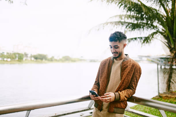 istock Young Arab Adult using Mobile Phone Outdoor 1283460182