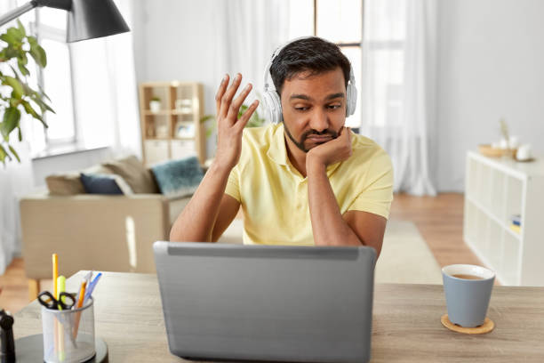 istock man in headphones with laptop working at home 1283460949