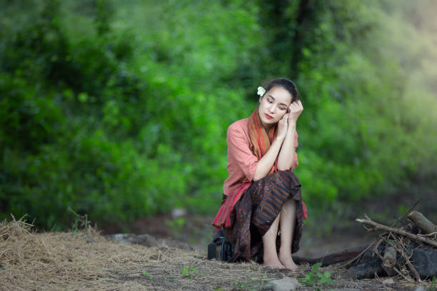 istock Young Woman Sitting On Land Against Trees 1283461137