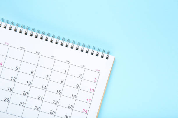 istock Paper calendar page on blue background 1283462546