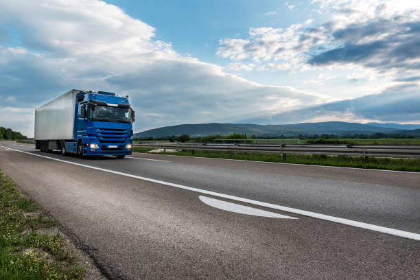 istock Blue semi trailer truck on a highway at sunset 1283462940