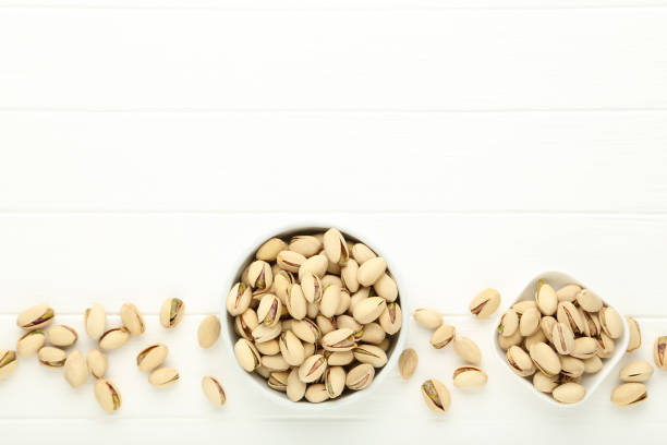 istock Pistachios in bowls on white wooden table 1283464063