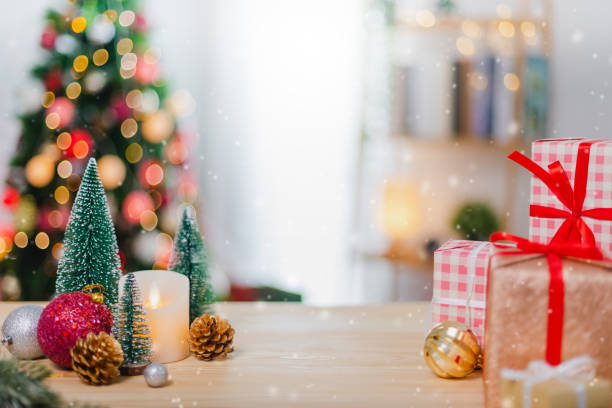 istock Christmas tree and New Year holidays gift box with decorative ornament on wood table with snowfall.Gifts and congratulations banner background concept. 1283465673