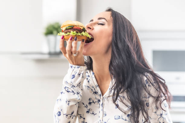 istock Enjoying a bite of a hamburger by a female. 1283466372