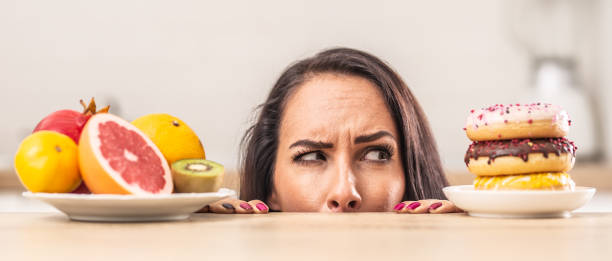 istock Suspicious expression over plate of donuts next to a plate of fruit. 1283466404
