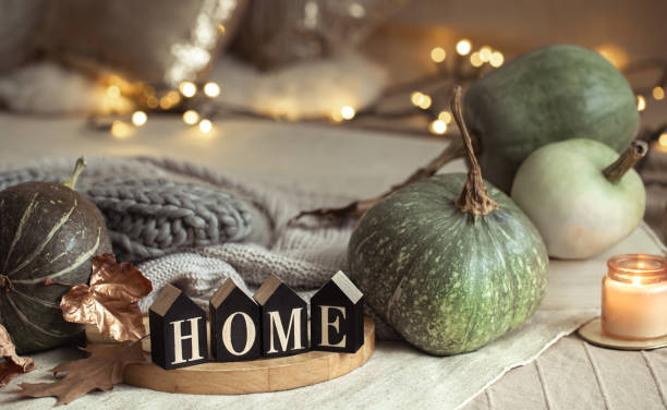 istock Composition homely autumn atmosphere in the interior with pumpkins and wooden letters with the words home, the concept of comfort and coziness. 1283473201