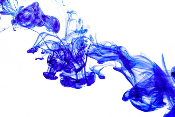 istock Blue ink injected into water from syringe, colour mixing with water creating abstract shapes 1283474496