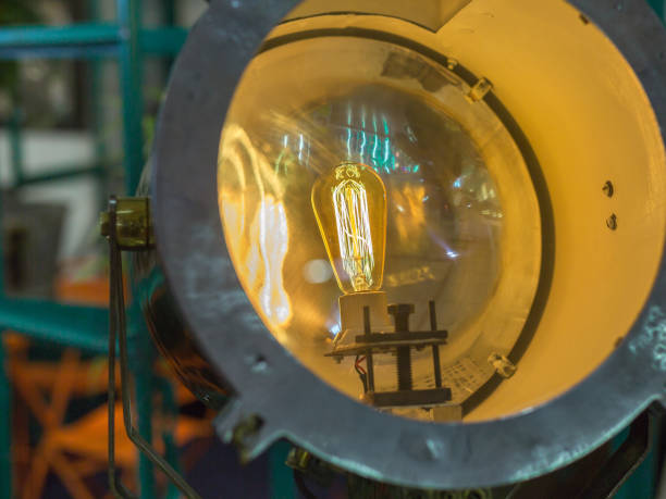istock Vintage Electric Light Bulb with Incandescent Filament inside Porthole-shaped Projector 1283474583