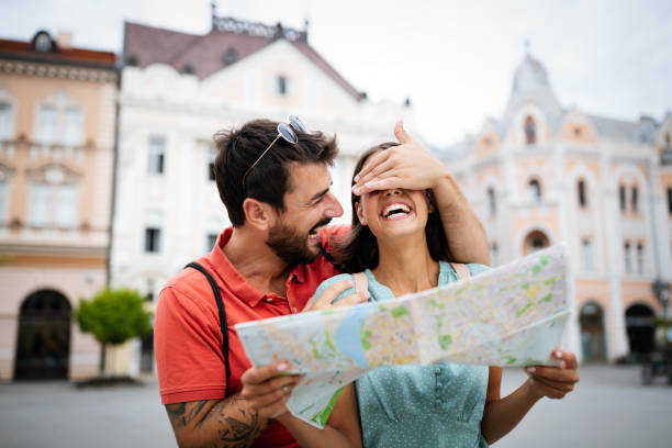 istock Happy young couple walking outdoors sightseeing and holding a map 1283476533