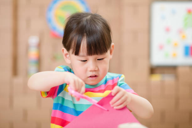 istock young girl using scissors cutting paper for making craft for home schooling 1283476761