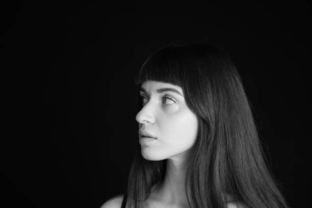 istock Studio portrait of a young woman against plain black background 1283477494