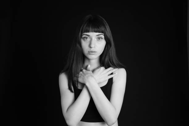 Black and white portrait of a sad woman. Man's hand on her head.