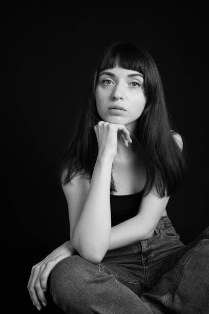 Studio portrait of a young woman against plain black background