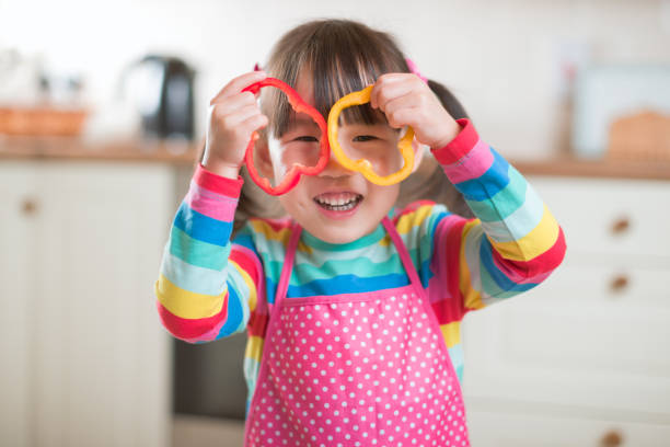 istock young girl put pepper ring on her face as glass against real kitchen background 1283477906