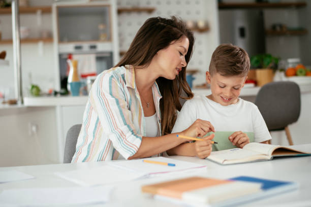 istock Mother helping her son with homework at home. 1283479219