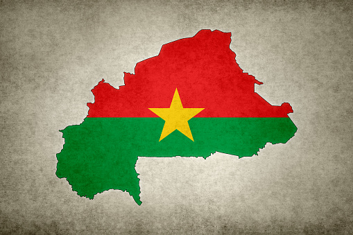 Grunge map of Burkina Faso with its flag printed within its border on an old paper.