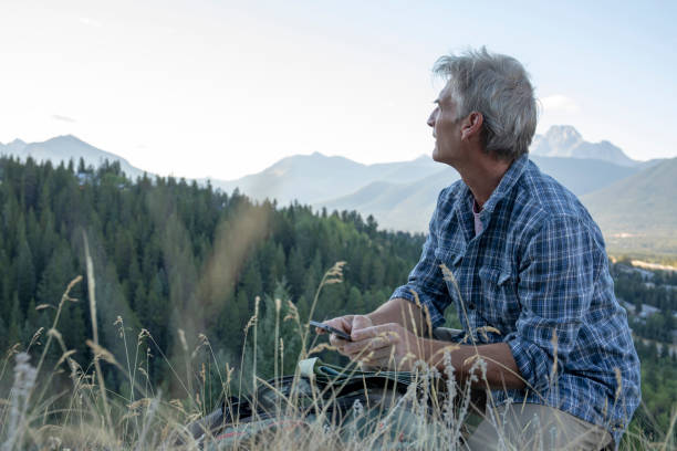 istock Man hikes through grassy meadow at sunrise 1283480460
