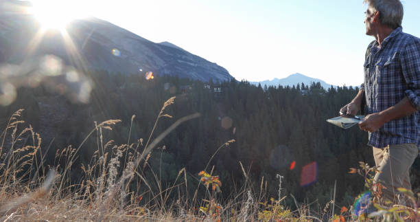 istock Man hikes through grassy meadow at sunrise 1283480663