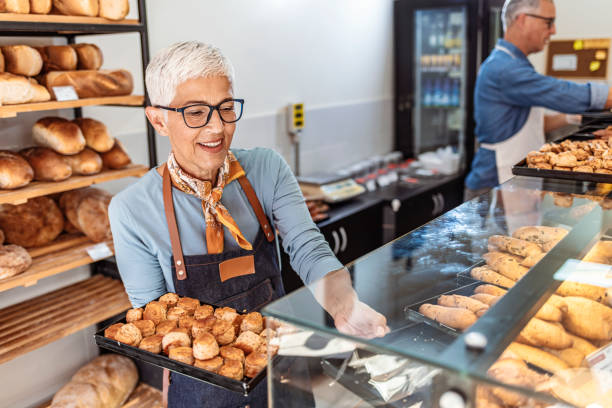 istock Senior woman selling bread and pastry 1283480700
