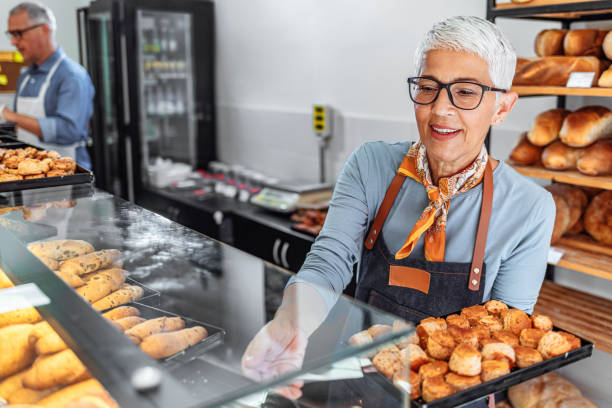 istock Mature female baker working at her shop 1283480707
