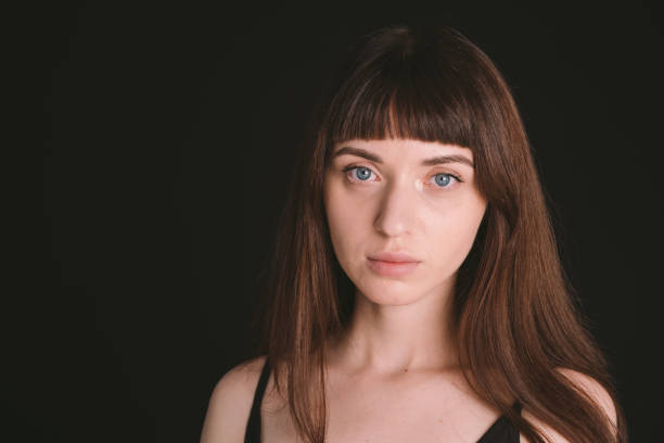 istock Studio portrait of a young woman against plain black background 1283480937