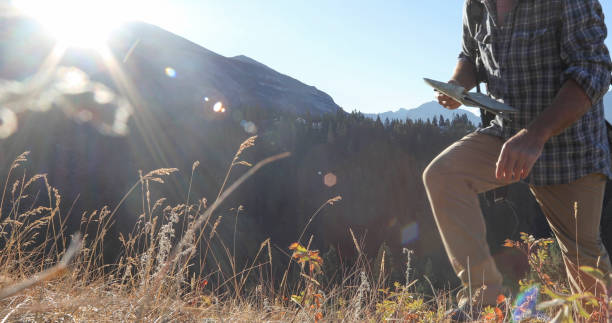 istock Man hikes through grassy meadow at sunrise 1283481522