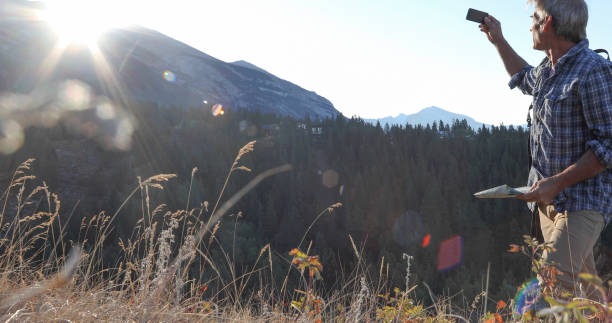 istock Man hikes through grassy meadow at sunrise 1283481531