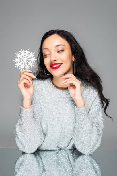 istock pleased woman with red lips holding decorative snowflake isolated on grey 1283482364