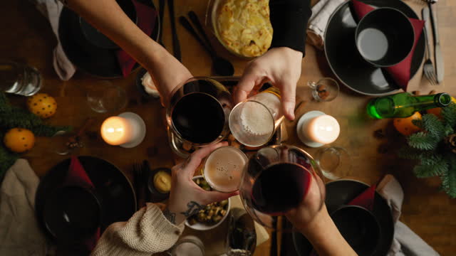 Family toasting with beer and wine at a Christmas Dinner. Seen from above.