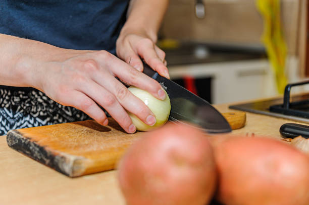istock A Female Chef is Peeling of a Raw Onion in the Kitchen. 1283484012