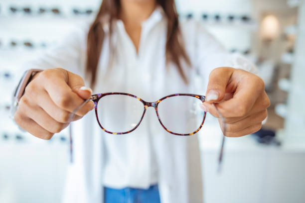 istock Optician giving new glasses to customer for testing and trying. 1283484354
