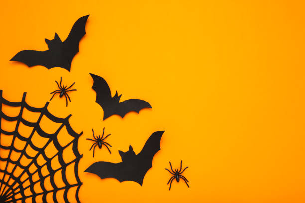 istock Halloween paper bats with spiderweb and spiders on orange background 1283485694