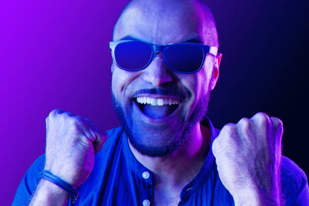 istock Black man in glasses shouting with happiness in neon light 1283486312