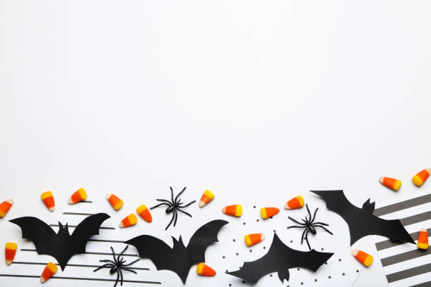 istock Halloween paper bats with candies and spiders on white background 1283487701