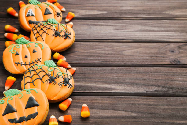 istock Halloween gingerbread cookies with candies on wooden table 1283488542