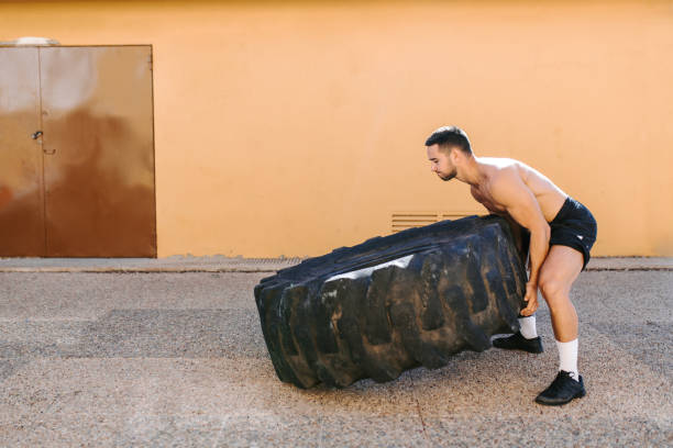 istock Fitness man lifting tire 1283491523