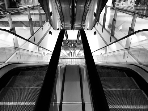 Black and white photo of an escalator, de identified