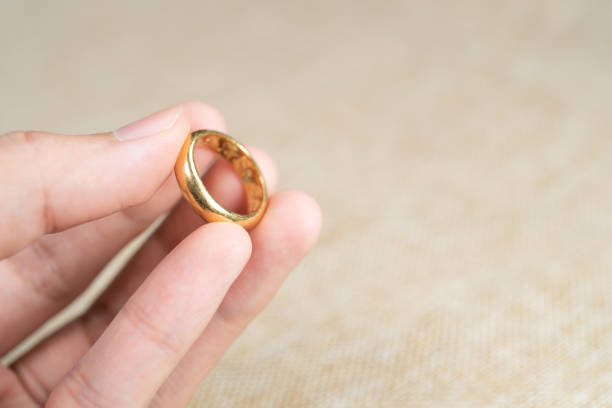 istock Man holding wedding ring over brown sack background. 1283496847