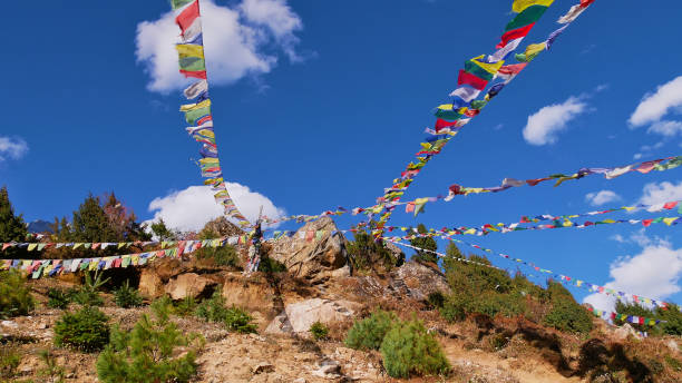 istock Several multi-colored Buddhist prayer flags peacefully waving in the wind above Namche Bazar, Khumbu, Himalayas, Nepal on sunny day. 1283497024