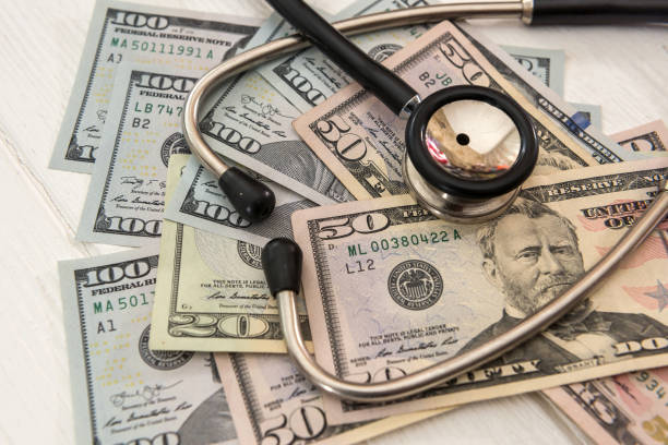 istock doctor stethoscope lying on a lot of  Dollar banknotes 1283497638