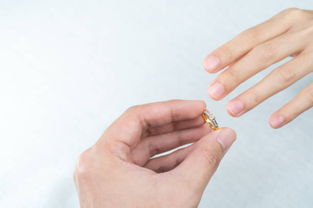 istock Man putting diamond ring on woman hand over white background. 1283497689