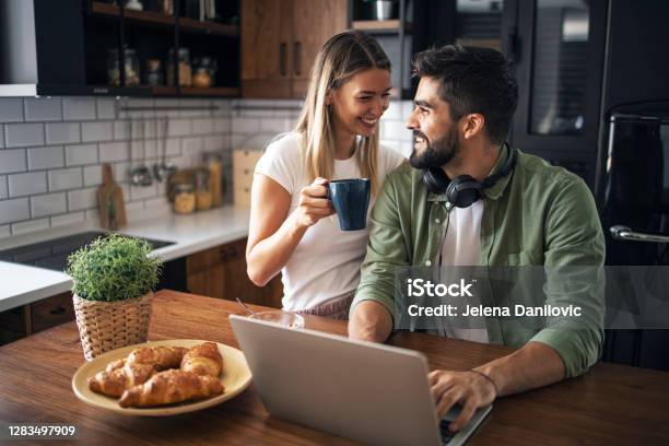 Lovely Couple Shopping Online In The Kitchen Stock Photo - Download Image Now - Couple - Relationship, Coffee - Drink, Young Couple