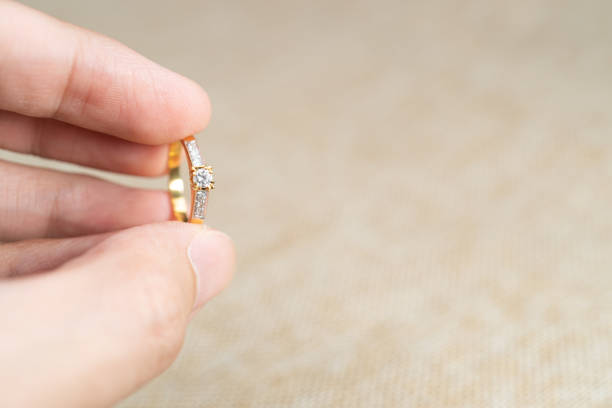 istock Man holding wedding ring over brown sack background. 1283498004