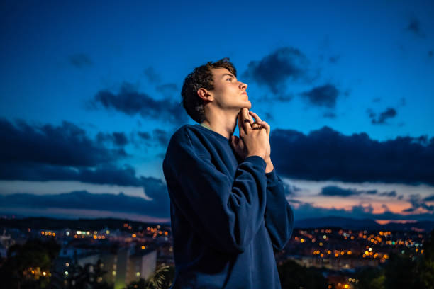 jeune homme occasionnel sentant l’espoir - evening prayer photos et images de collection