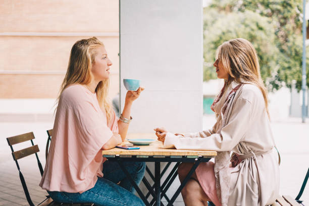 istock Two beautiful blond girls talking over breakfast. 1283499527
