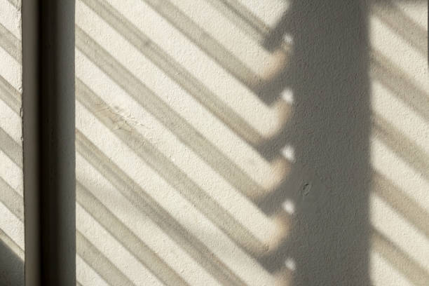 istock Dark shadows from the louver window to the concrete wall. 1283499749