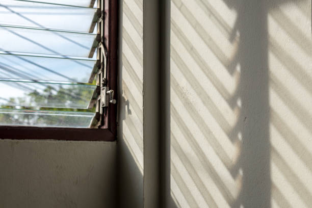istock The sun shines through the louver windows into the concrete wall. 1283499763