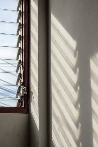 istock The sun shines through the louver windows into the concrete wall. 1283499793