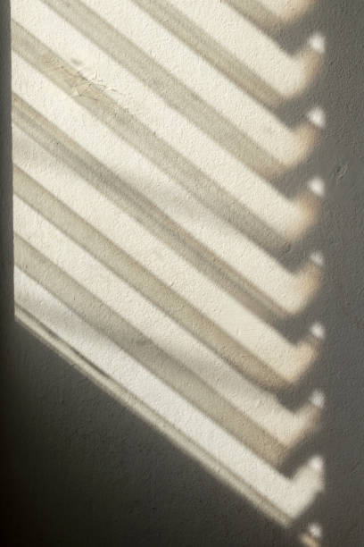 istock Dark shadows from the louver window to the concrete wall. 1283499810