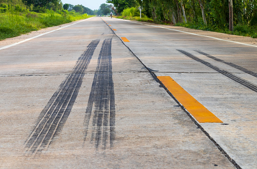 Background of black tire traces. Braking and stopping of truck wheels on concrete road surfaces in rural Thailand.